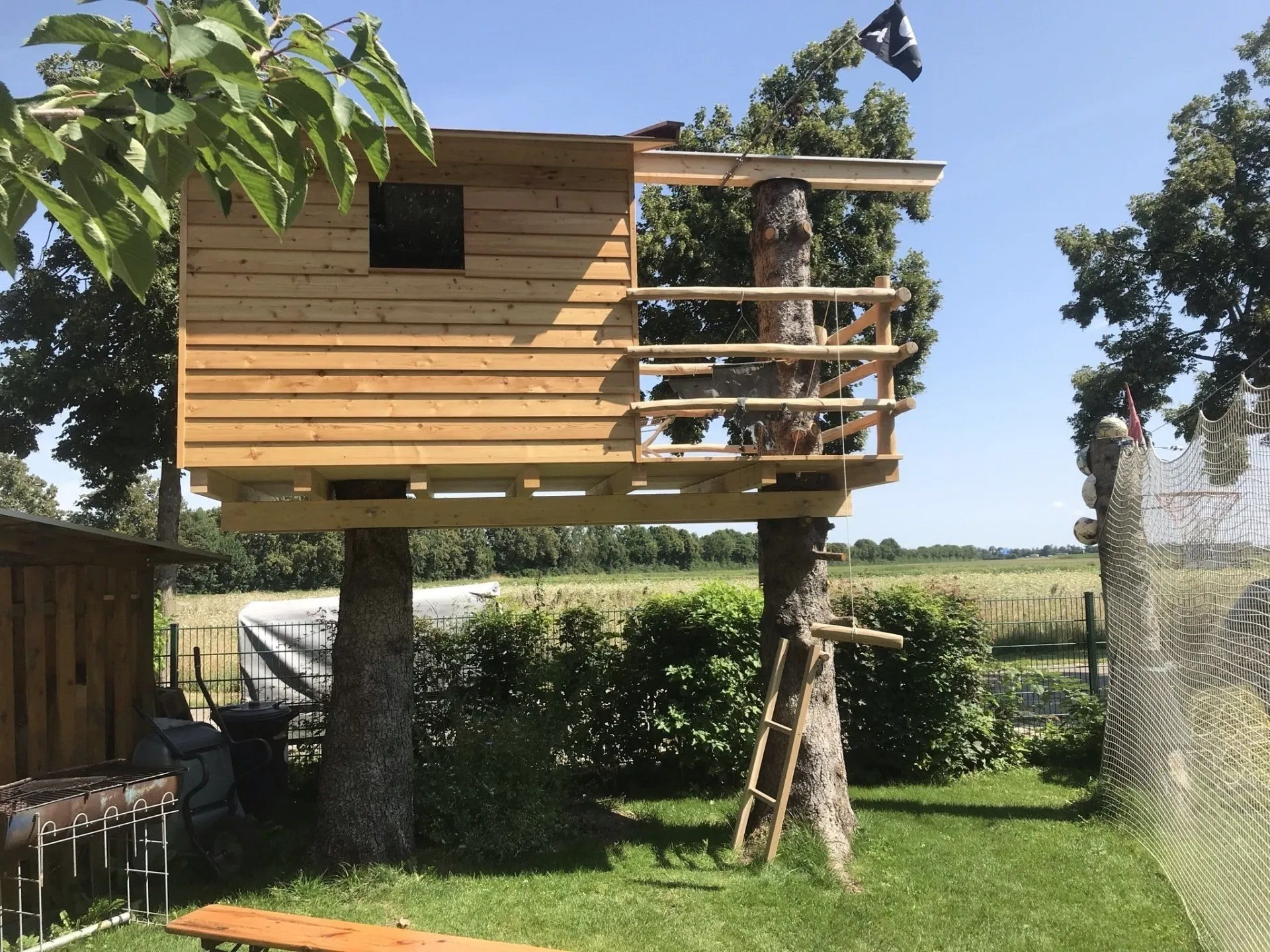 Baumhaus aus Holz mit umlaufendem Balkon und Geländer