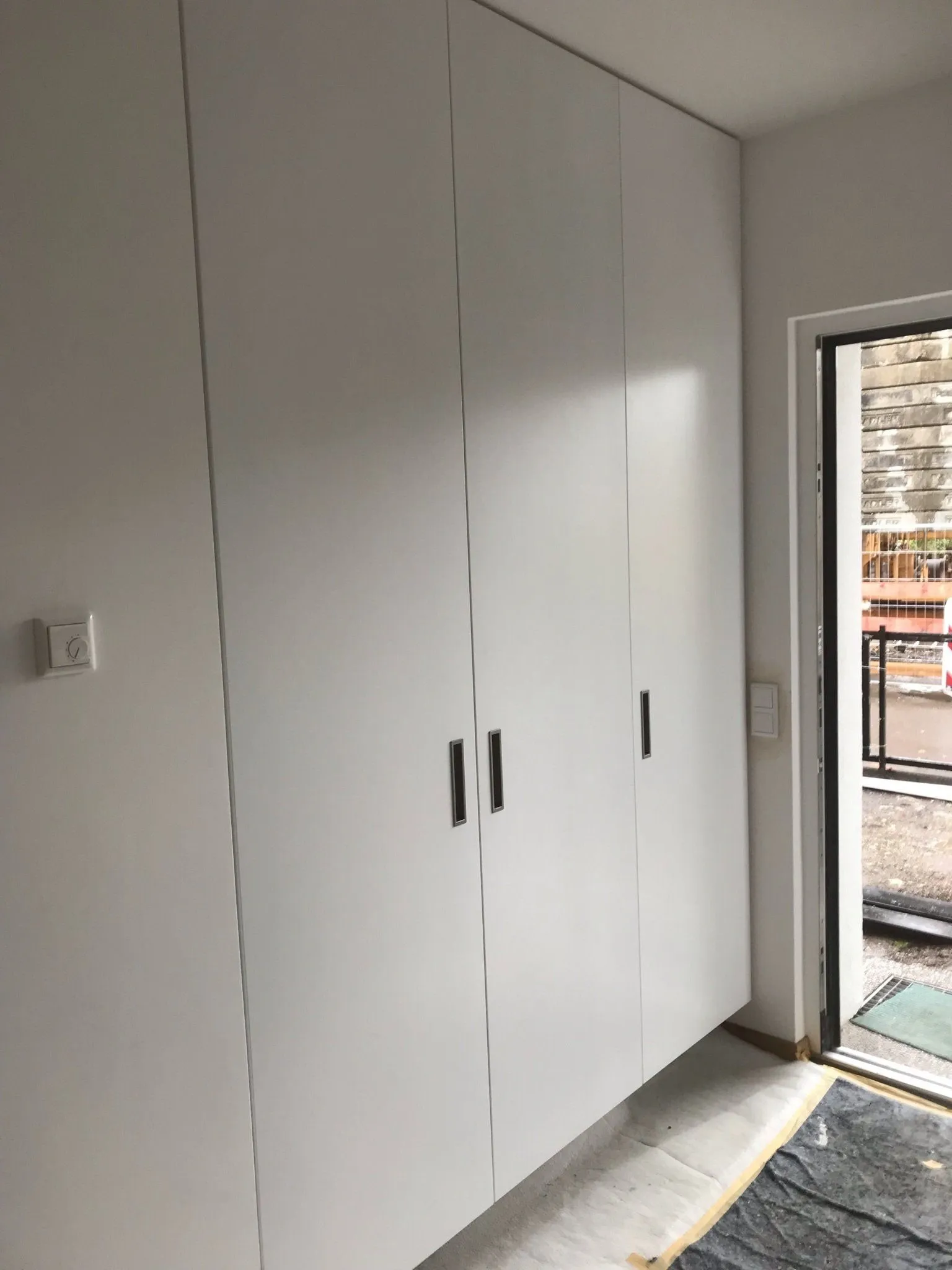 Wandbündiger Einbauschrank in Weiß mit grifflosen Türen