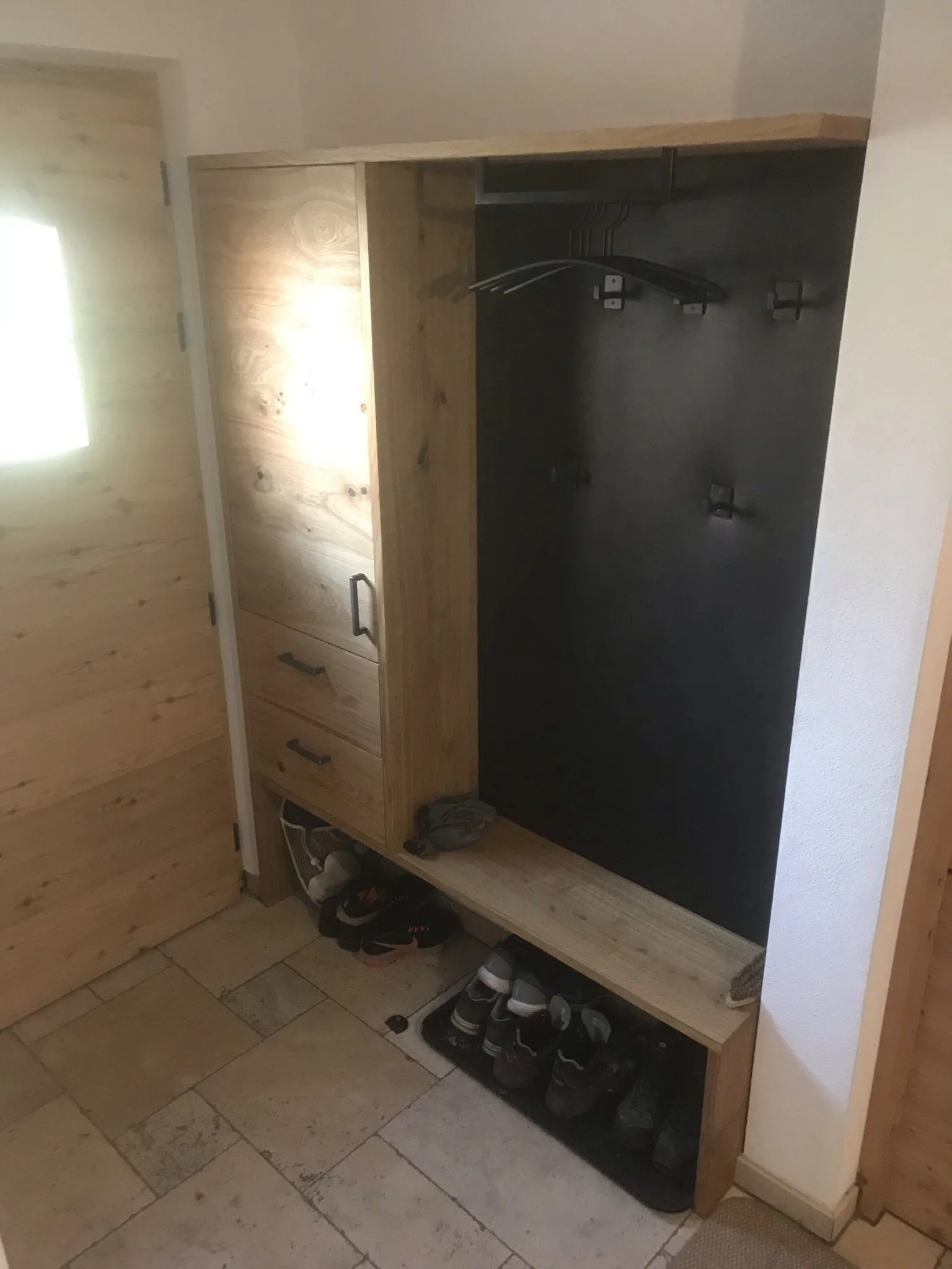 Garderobe aus Altholz im Eingangsbereich mit Sitzbank