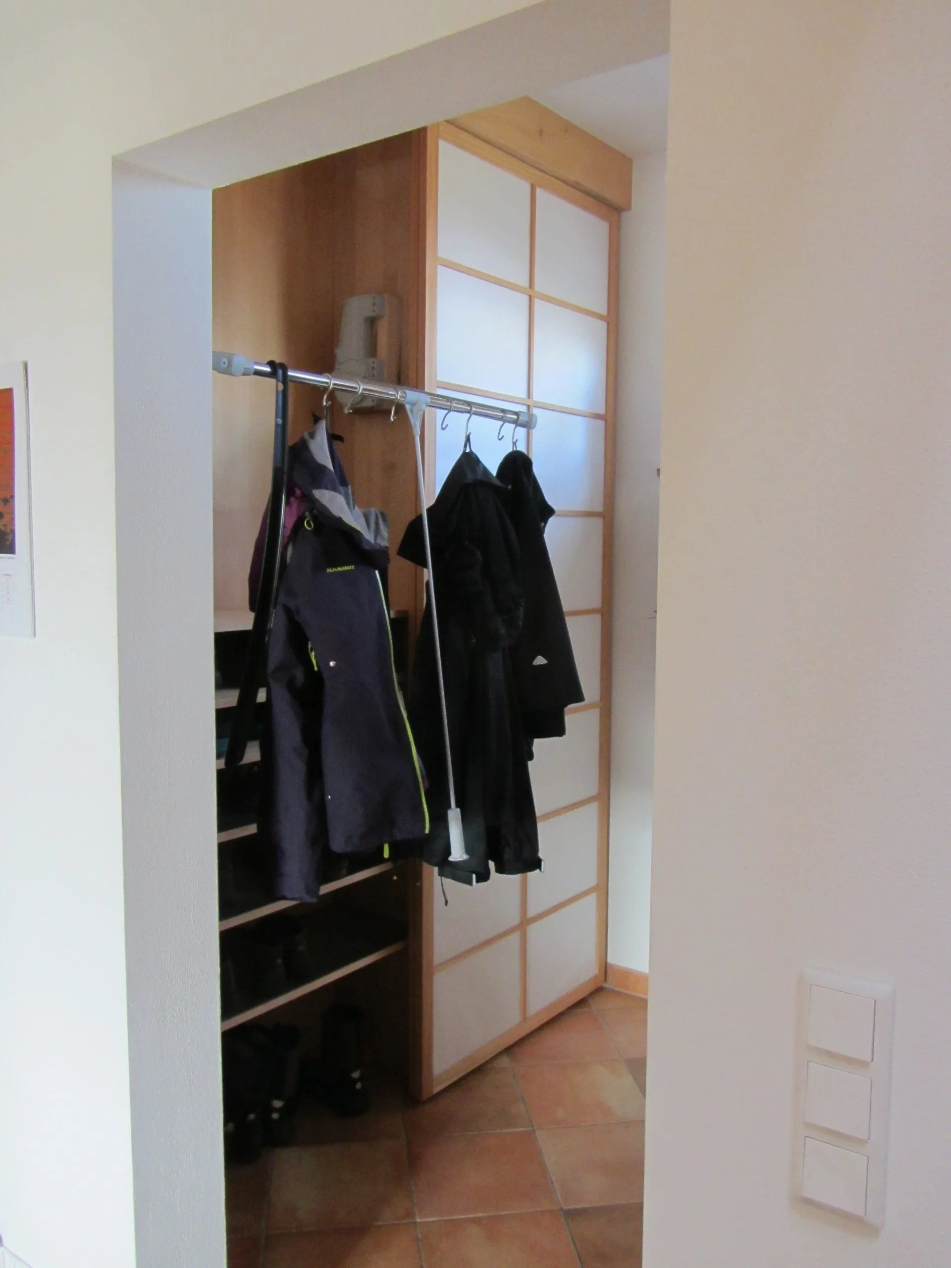 Garderobenschrank im Flur mit Schiebetür und Kleiderstange