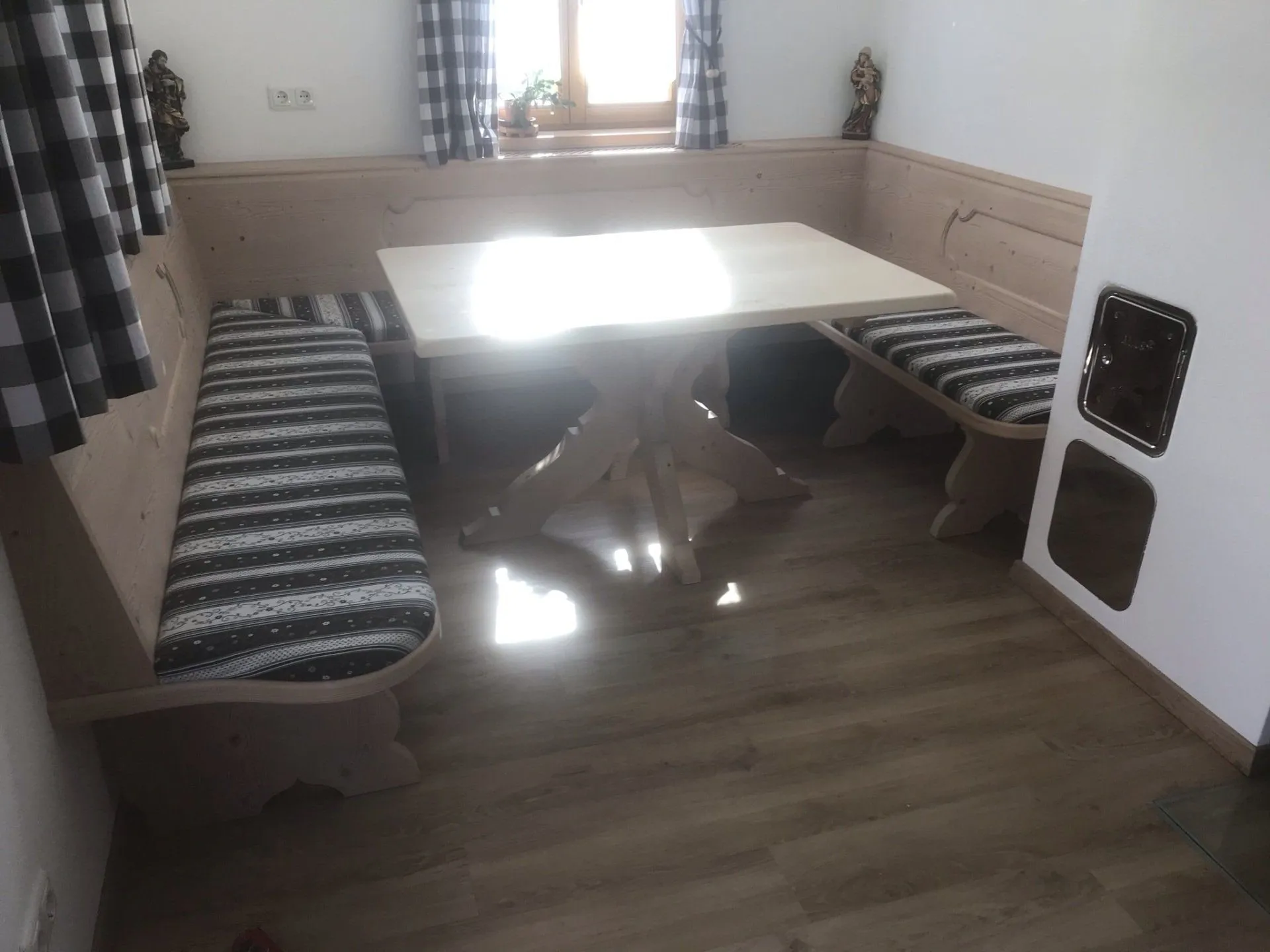 Eckbank mit Tisch in einer Stube mit Sprossenfenstern