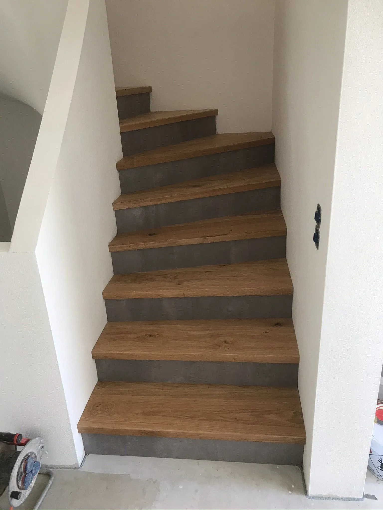 Gerade Treppe mit Stufen aus Eiche zwischen zwei Wänden
