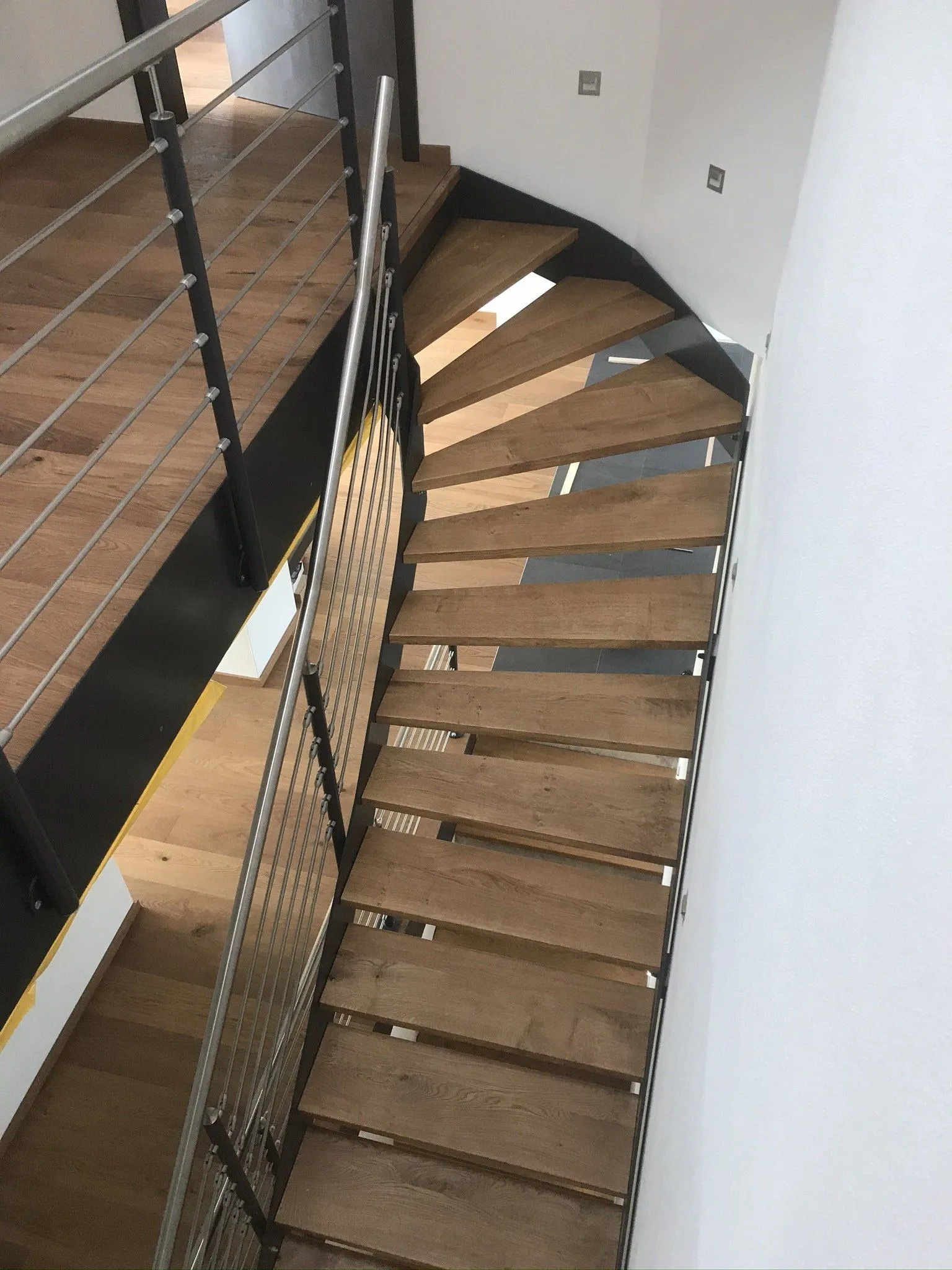 Offene Treppe mit Eichenstufen und filigranem Stahlgeländer