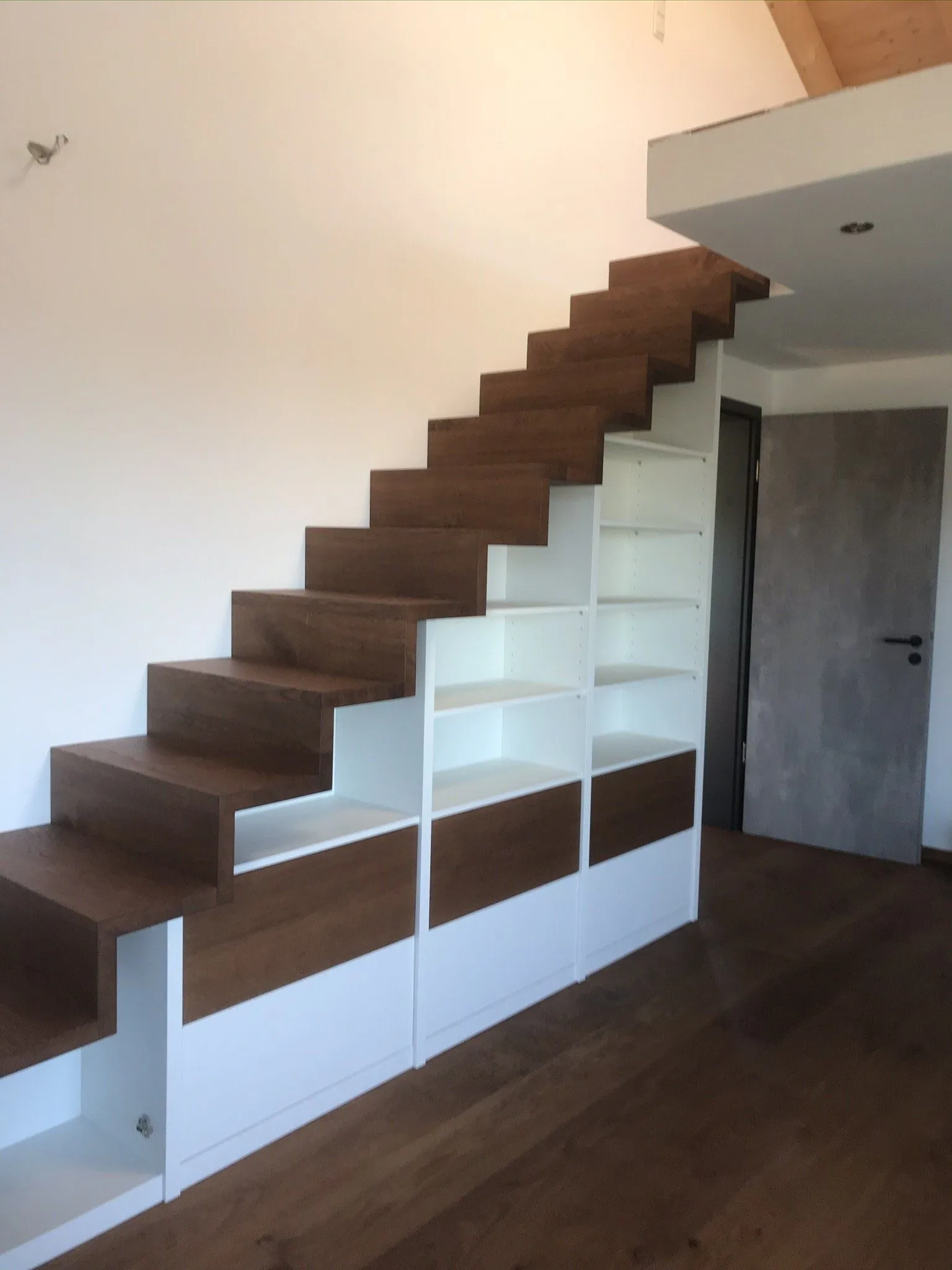 Treppe mit weißem Stauraum-Unterbau und offenen Fächern