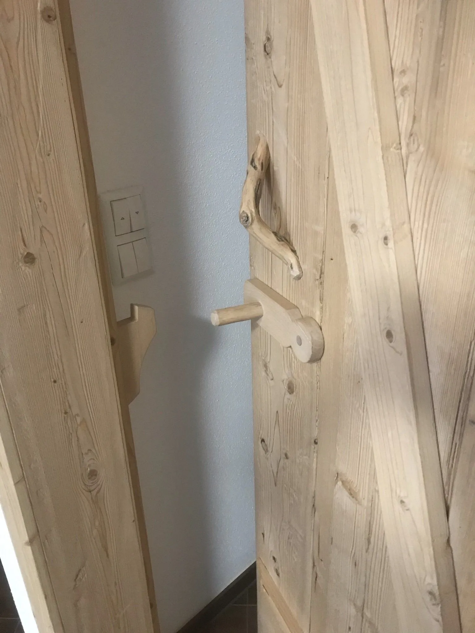 Detail einer Altholzwand mit handgeschmiedeten Kleiderhaken