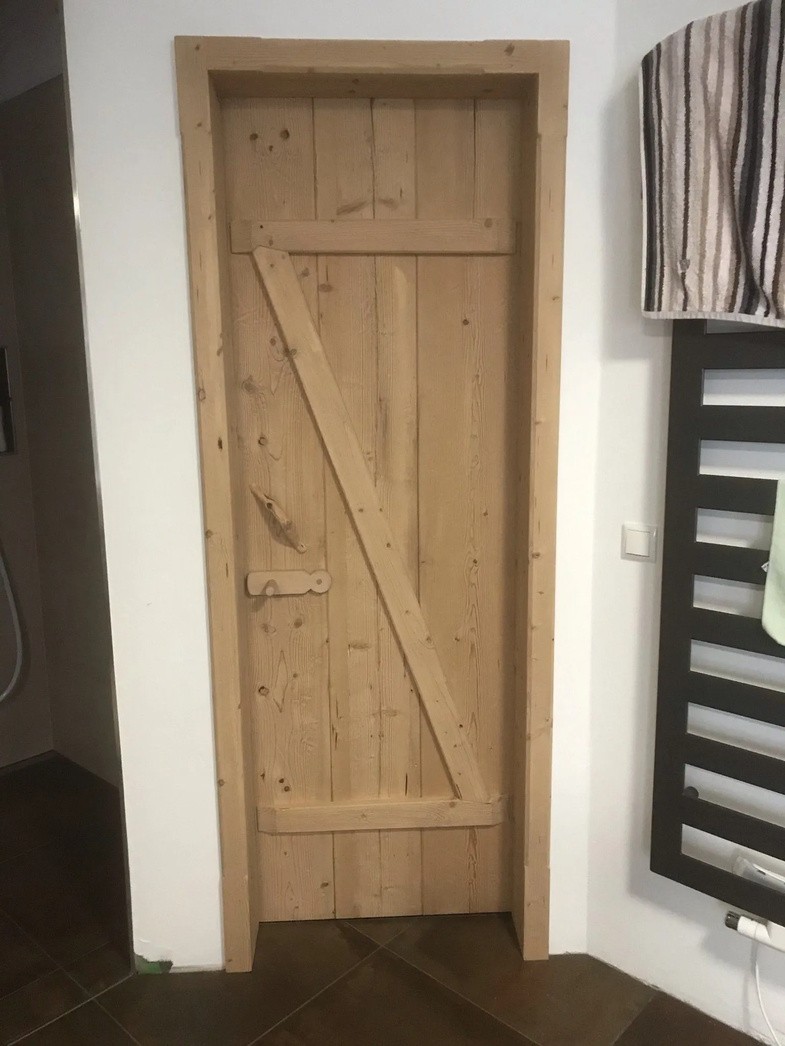 Zimmertür aus Altholz mit sichtbarer Diagonalstrebe